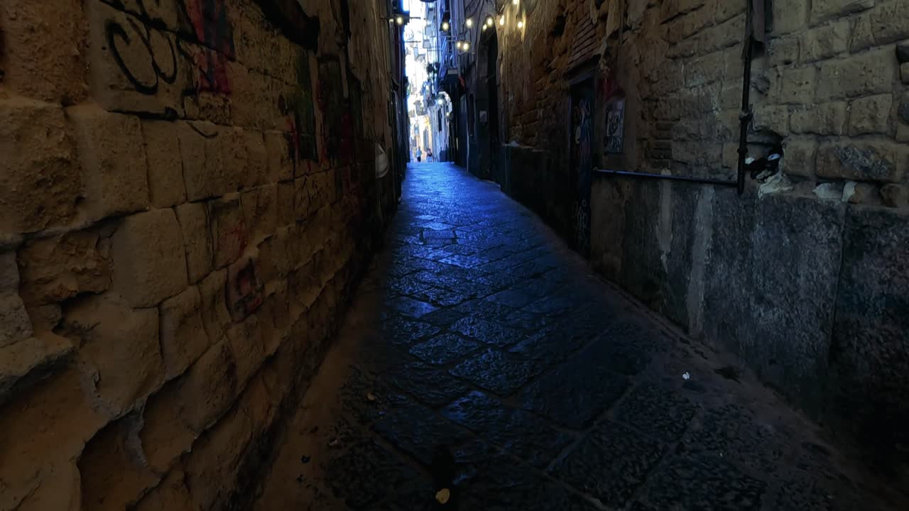 A dimly lit alleyway with stone walls