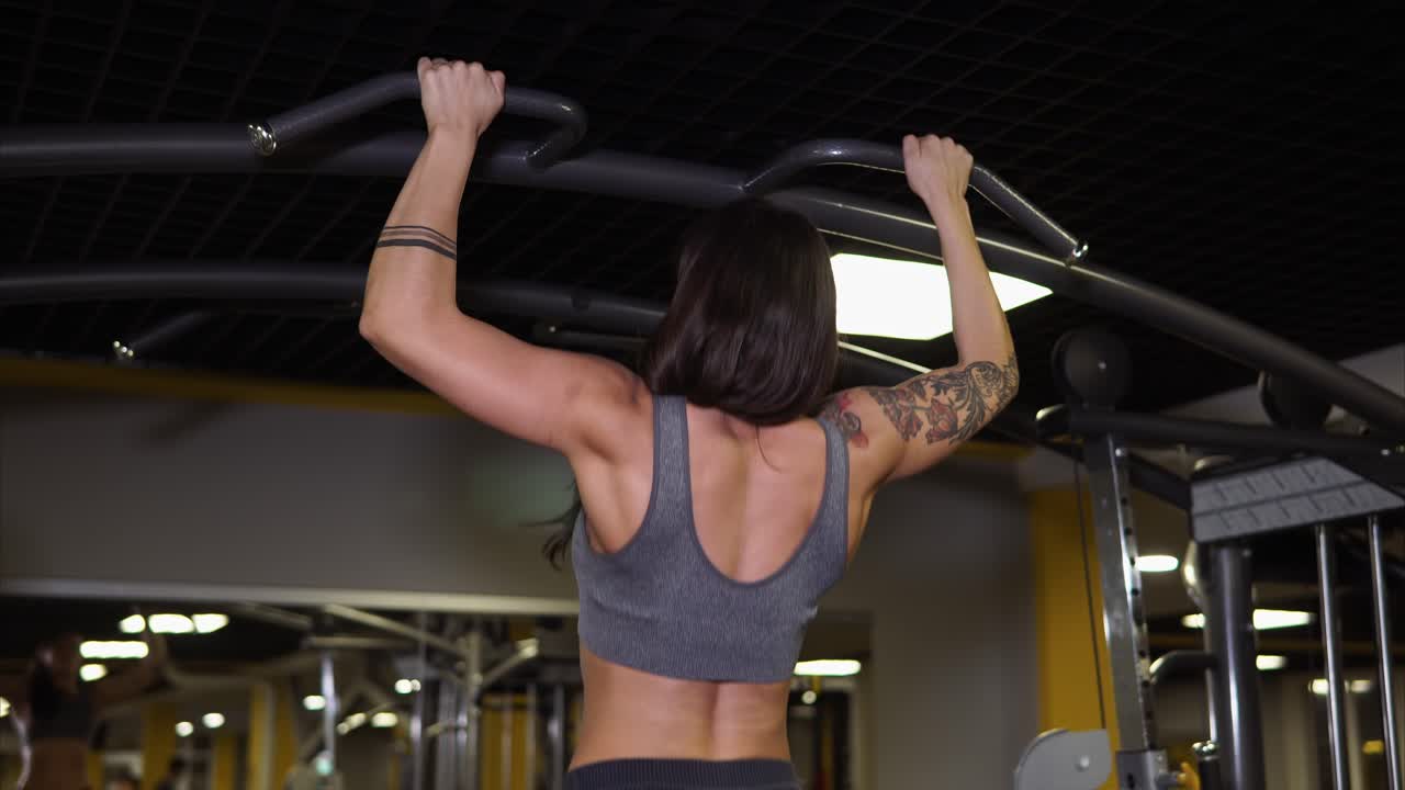 Woman Doing Pull-Ups in Gym