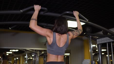 woman doing pull-ups in gym