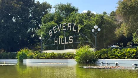 famous beverly hills sign in beverly garden low angle, pond of water on a picturesque landscape day