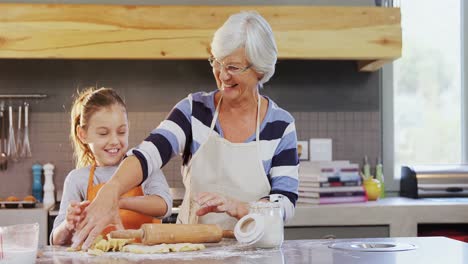 Happy-grandmother-and-little-girl-with-rolling-pin-kneading-dough-4K-4k