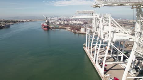 oakland estuary and industrial port, 4k drone shot with shipping cranes in foreground