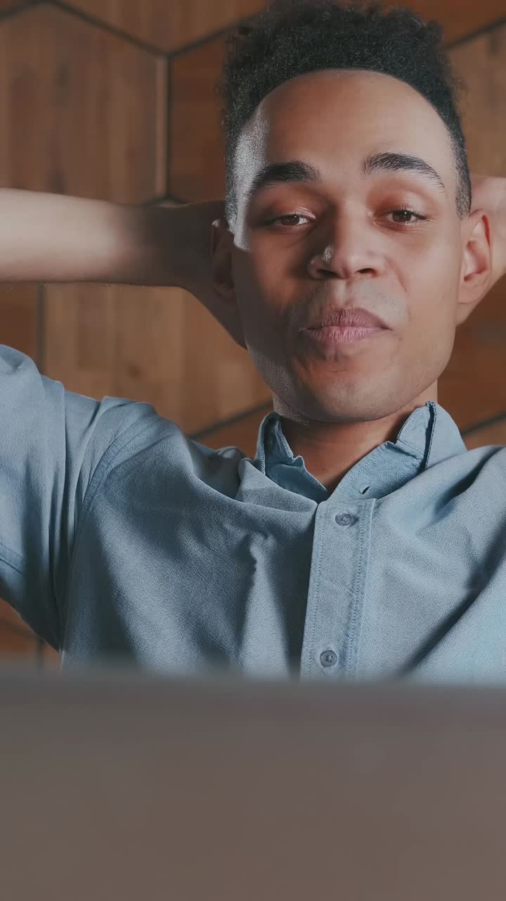 Young african american man office clerk with smile finishes work with laptop