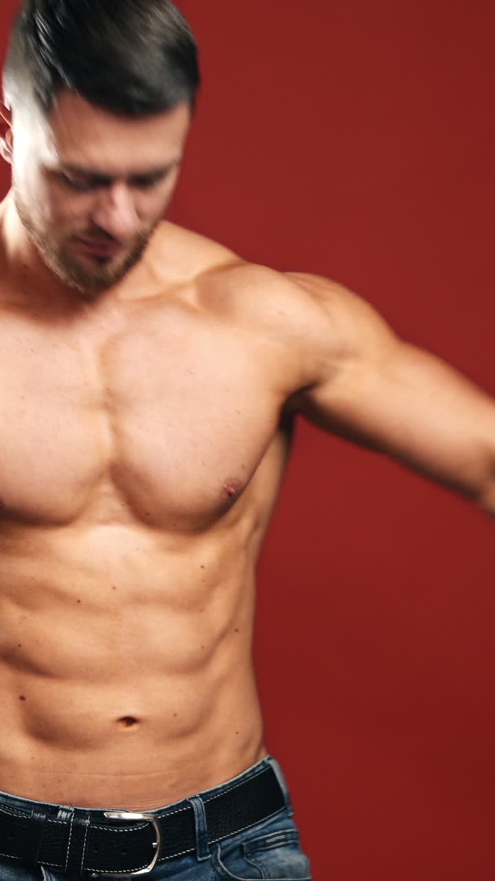 Portrait of bodybuilder in studio. Shirtless athlete with muscular body showing his trained biceps. Topless sportsman isolated in studio. Vertical video