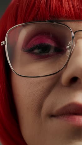 close-up of woman with red wig and glasses