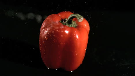 agua rociada sobre la pimienta en cámara súper lenta