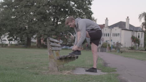 Young-Attractive-Man-Tying-His-Shoes-on-a-Bench-Before-He-Sets-of-For-a-Run,-In-Slow-Motion---Ungraded