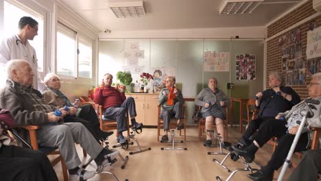 senior men and women doing pedal exercises and lifting dumbbells at rehabilitation center