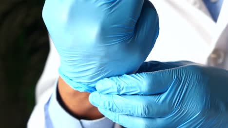 el médico se pone guantes médicos azules.