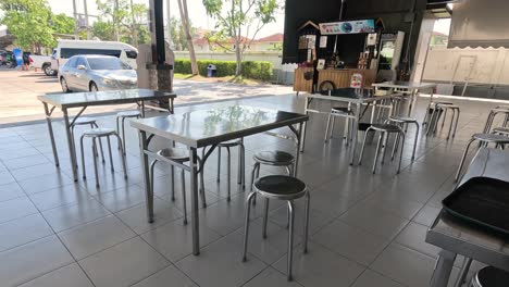 una persona camina por una cafetería tranquila y vacía.