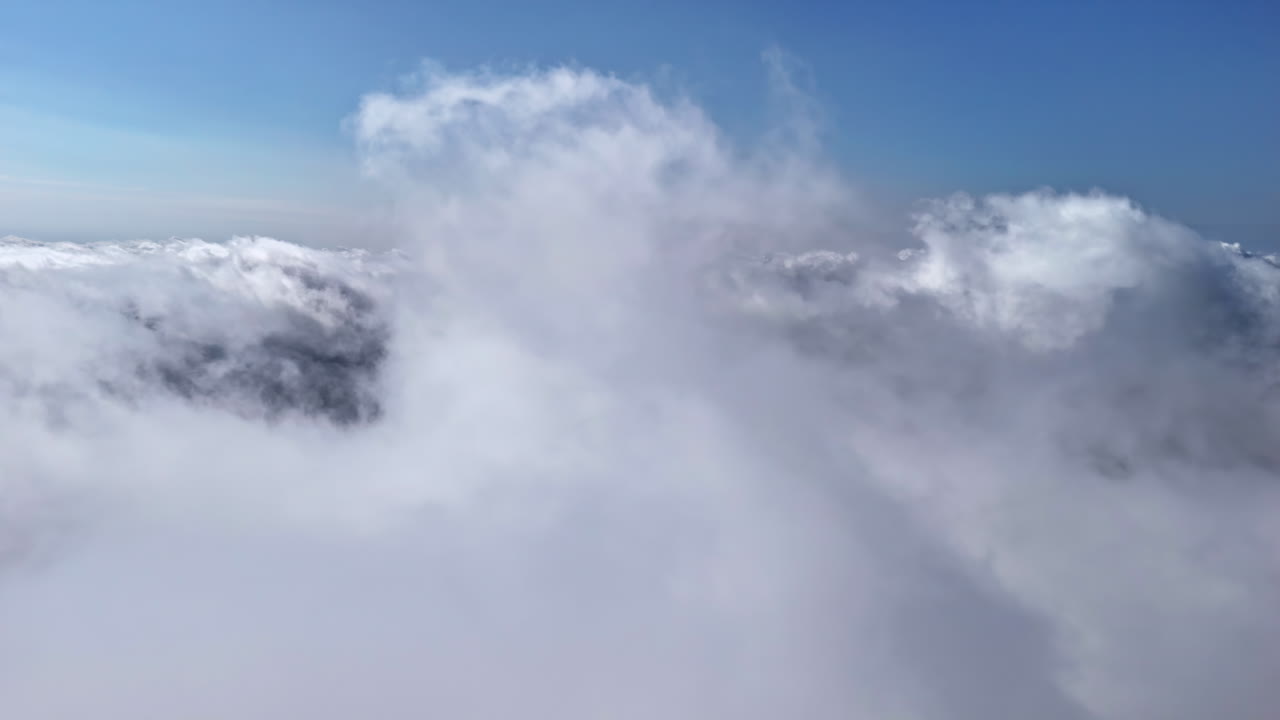 Aerial orbit clouds with soft blue sky and sunlight breaking through mist, natural backdrop