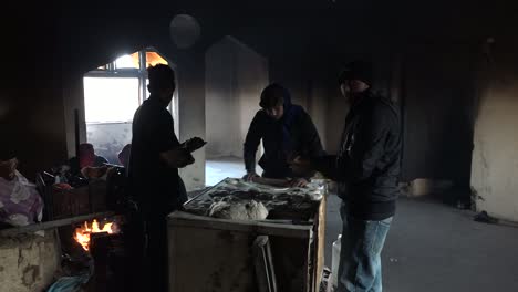 refugees baking bread in a damaged building