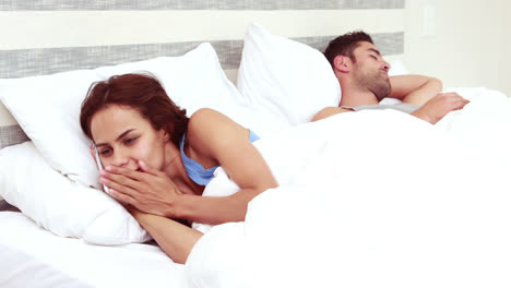 Woman-having-phone-call-while-man-is-sleeping