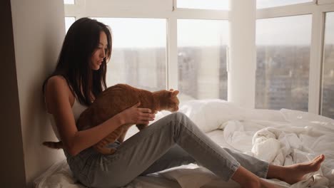 asian woman with kitten indoors