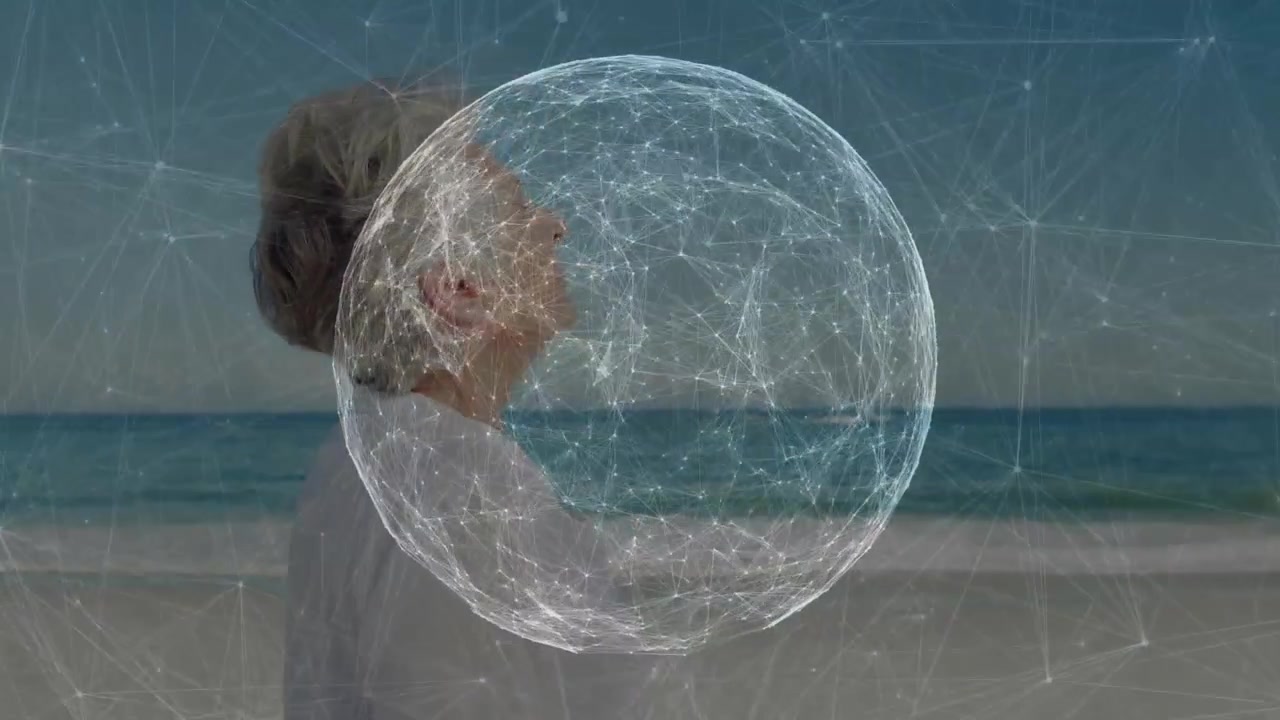 Mulher idosa olhando para o horizonte e ativando esfera digital giratória sobre a praia para demonstração de tecnologia