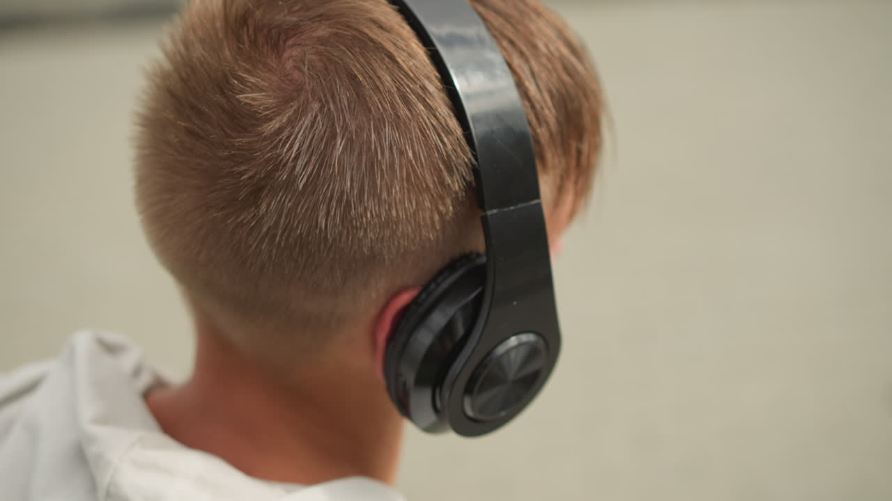 Teen listening music, Teenager with headphones walking through bustling city streets, Adolescent male actively engaging with music while surrounded by urban surroundings and lively crowds