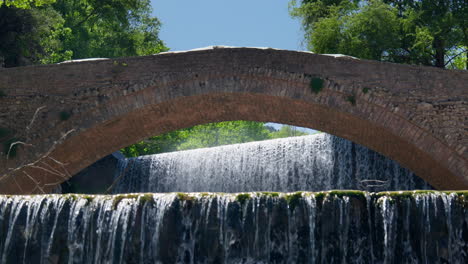 historical stone arch bridge palaiokarya waterfall slow motion dolly