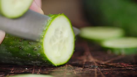 pepino cortado con un cuchillo en una tabla de cortar.