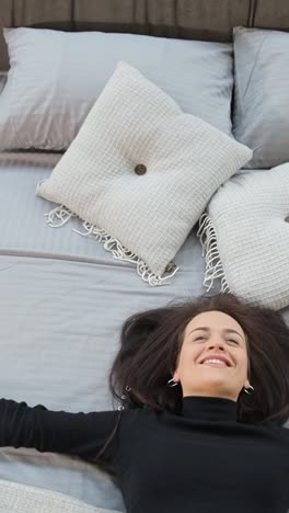 woman tests beds at a furniture store to show bedding options woman tests different beds in a furniture store sitting on one and then lying down with arms outstretched the video displays various bedding options at the store