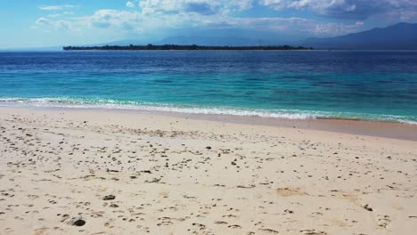 Bali,-Indonesia,-Hermosa-Agua-De-Mar-Color-Aguamarina,-Playa-De-Arena-E-Isla-Tropical-En-La-Distancia