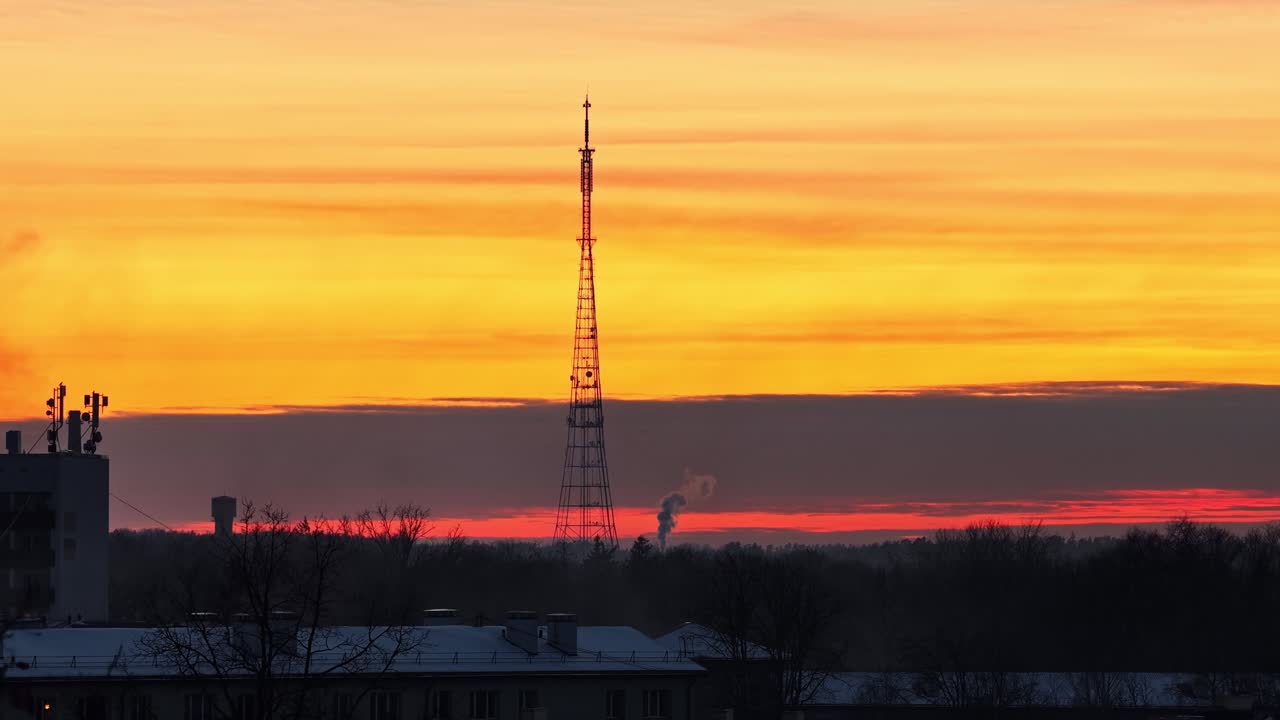 Silhueta de torre de transmissão contra um céu colorido durante o nascer ou pôr do sol