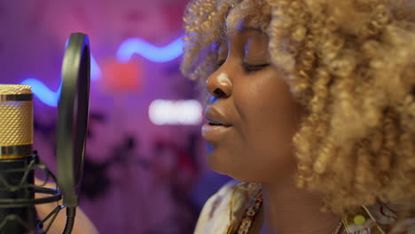 woman singing into a microphone in a recording studio