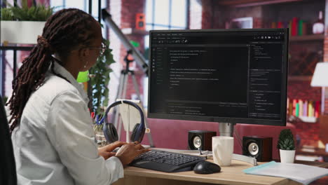 developer at computer desk coding while listening music