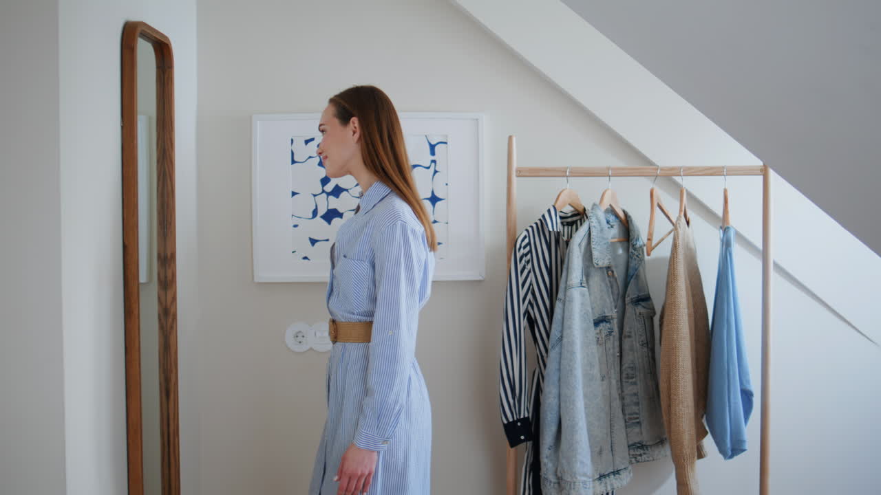 Smiling woman looking mirror reflection choosing outfit for workday at home