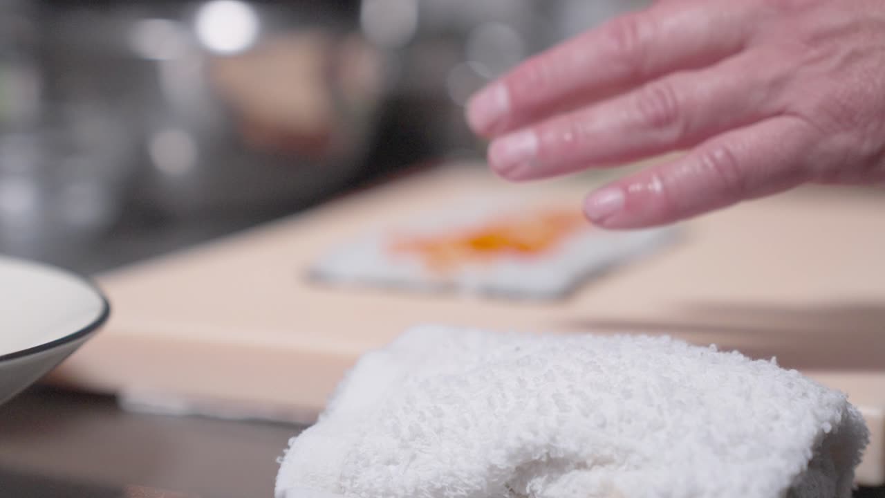 A roaming up-close shot captures a sushi roll being made, showcasing the detailed process of sushi preparation. Perfect for culinary, sushi-making, and professional kitchen content.