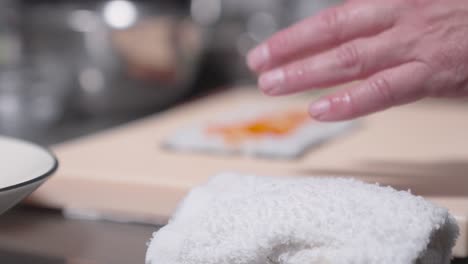 a roaming up-close shot captures a sushi roll being made, showcasing the detailed process of sushi preparation. perfect for culinary, sushi-making, and professional kitchen content.