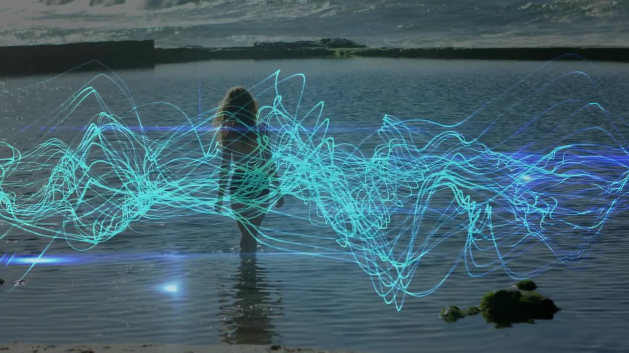 Donna che entra in acqua fino alla vita, avviando una forma d'onda verde acqua che si anima intorno al busto per una dimostrazione tecnologica.