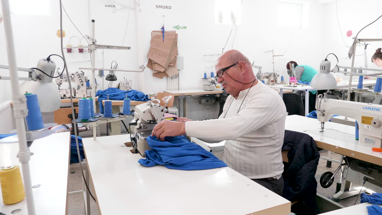 retrato de un hombre en una máquina de coser en una fábrica de coser