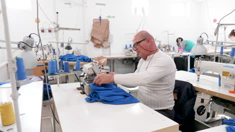 portrait of a man at a sewing machine in a sewing factory