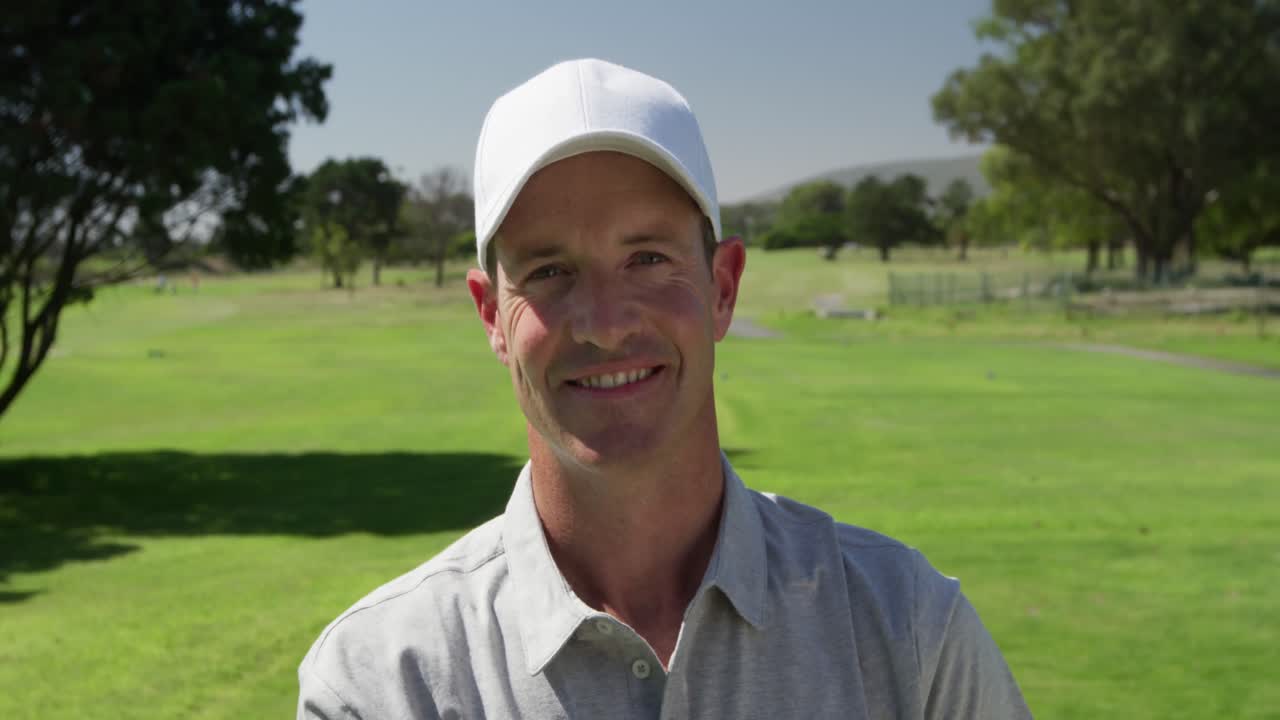 골프 코스에서 카메라에 미소 짓는 백인 남성 골프 선수