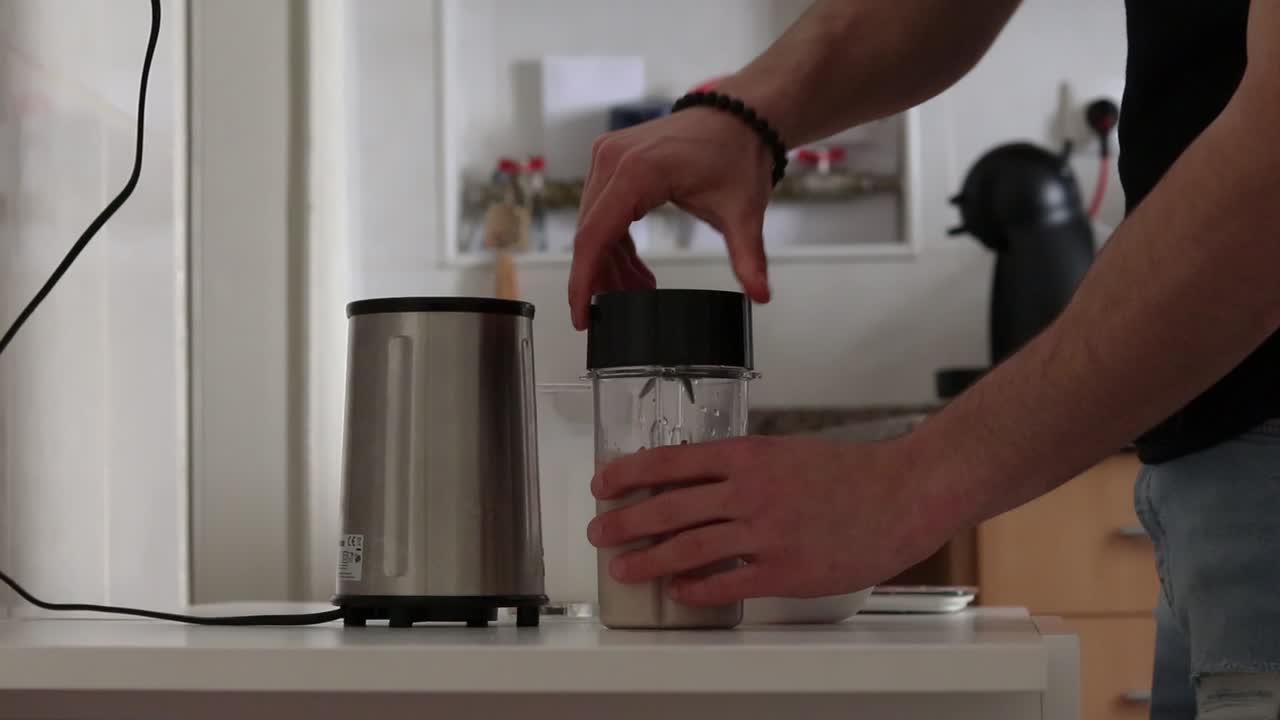 Man making a milkshake with frozen raspberries and oat milk, part two.
