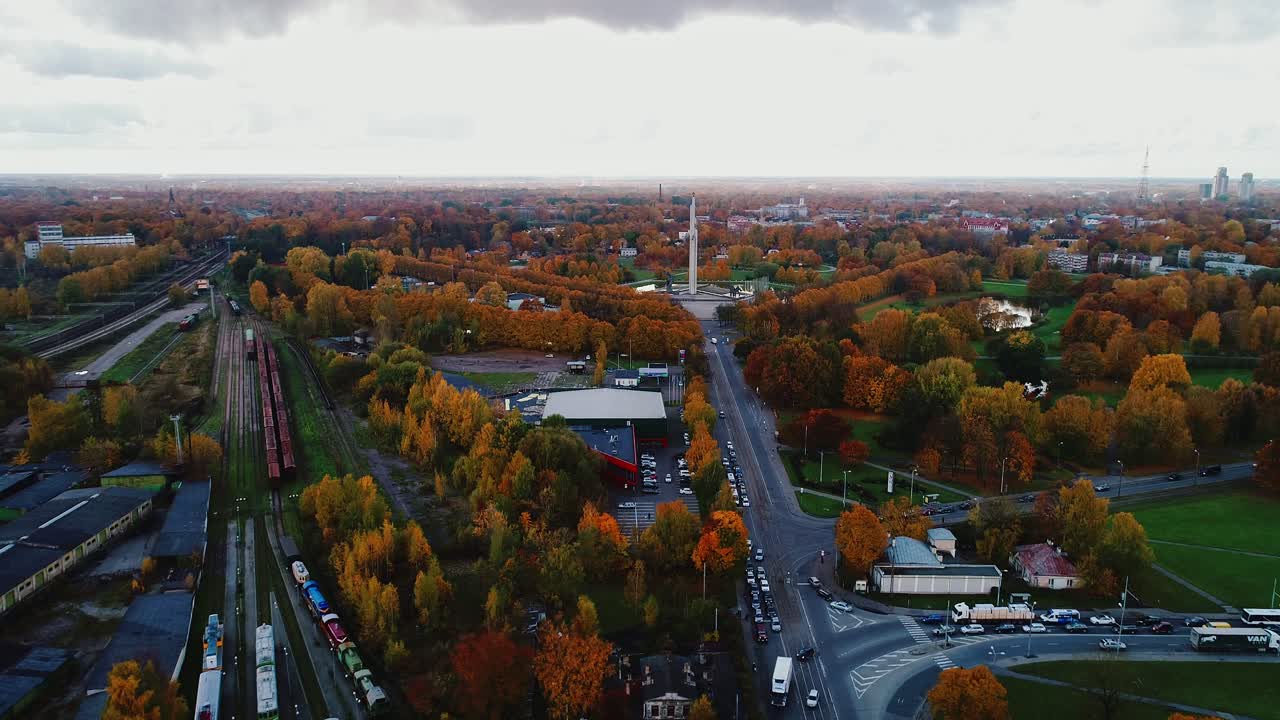 Panoramic aerial shows trains, roads, parks beneath vivid fall trees, 10.10.2020