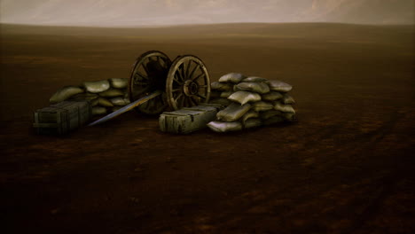 historic battlefield setup with cannon and sandbags in arid landscape