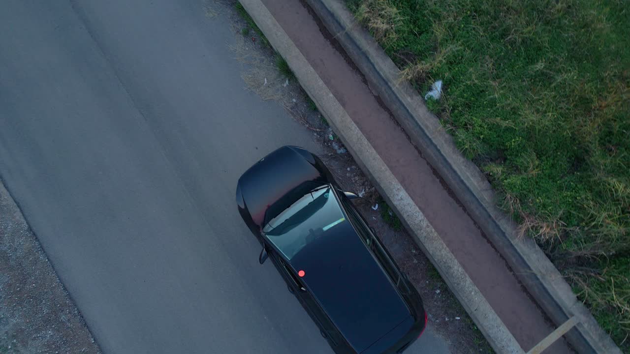 Luchtfoto van een voertuig met een knipperend V16-noodsignaallicht, dat een stop of pech langs de weg signaleert