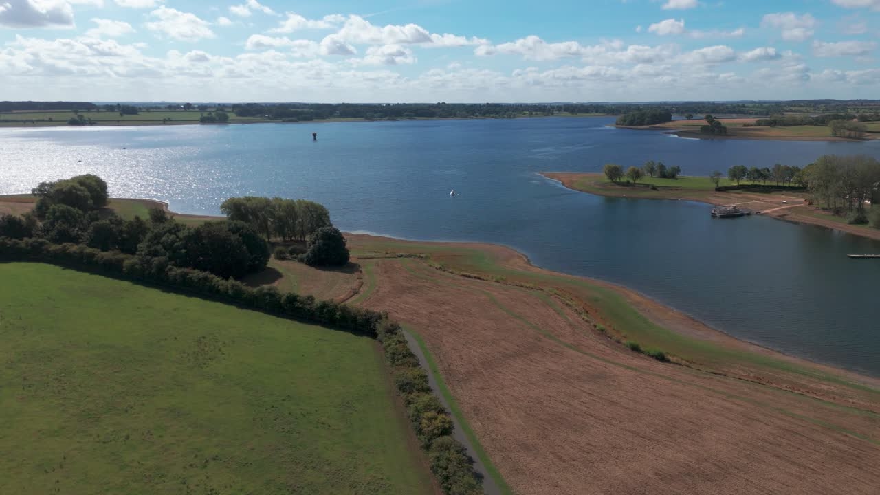 Aerial view of Whitwell's serene lake and fields under a blue sky