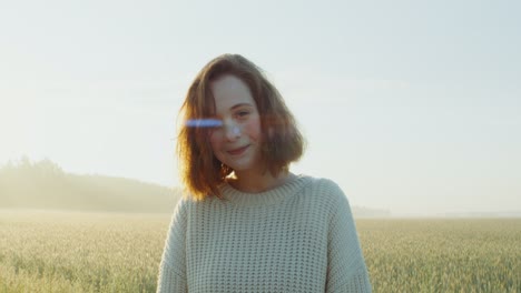 woman smiling in a wheat field at sunrise