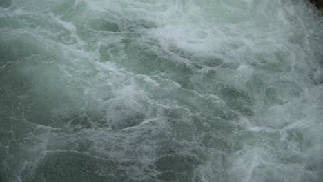 water swirl in canal flowing and splashing water in cold river.
