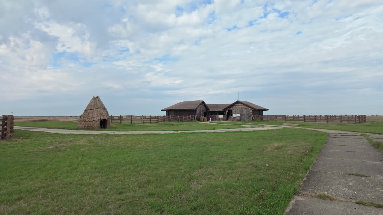 Traditional thatched barn with corral on the endless Hortobágy plain on a calm cloudy day in Hungary