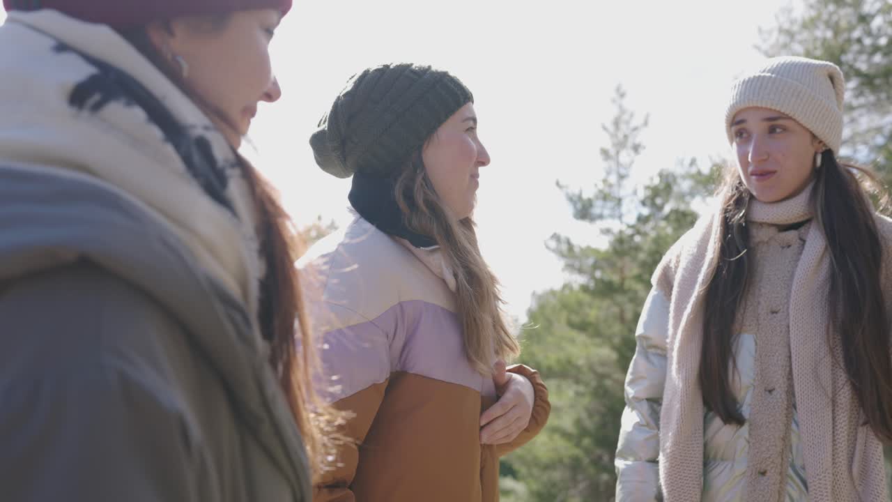 Three women wearing winter clothing outdoors