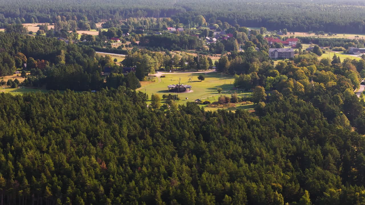 Aerial view of rural Jurkalne village and pine forest landscape in Latvia​.