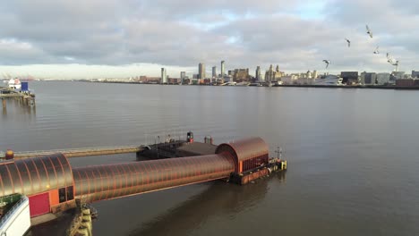 woodside ferry village terminal aerial left panning view birkenhead liverpool harbour skyline pigeons fly through shot