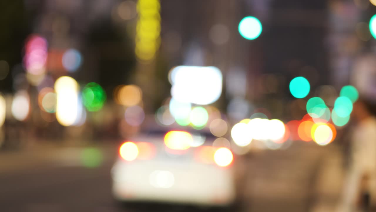 Abstract defocused lights of city at night with blurry cars driving through street