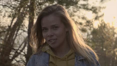 the portrait of adult girl walking in sunny forest