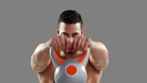 hombre musculoso serio levantando kettlebell