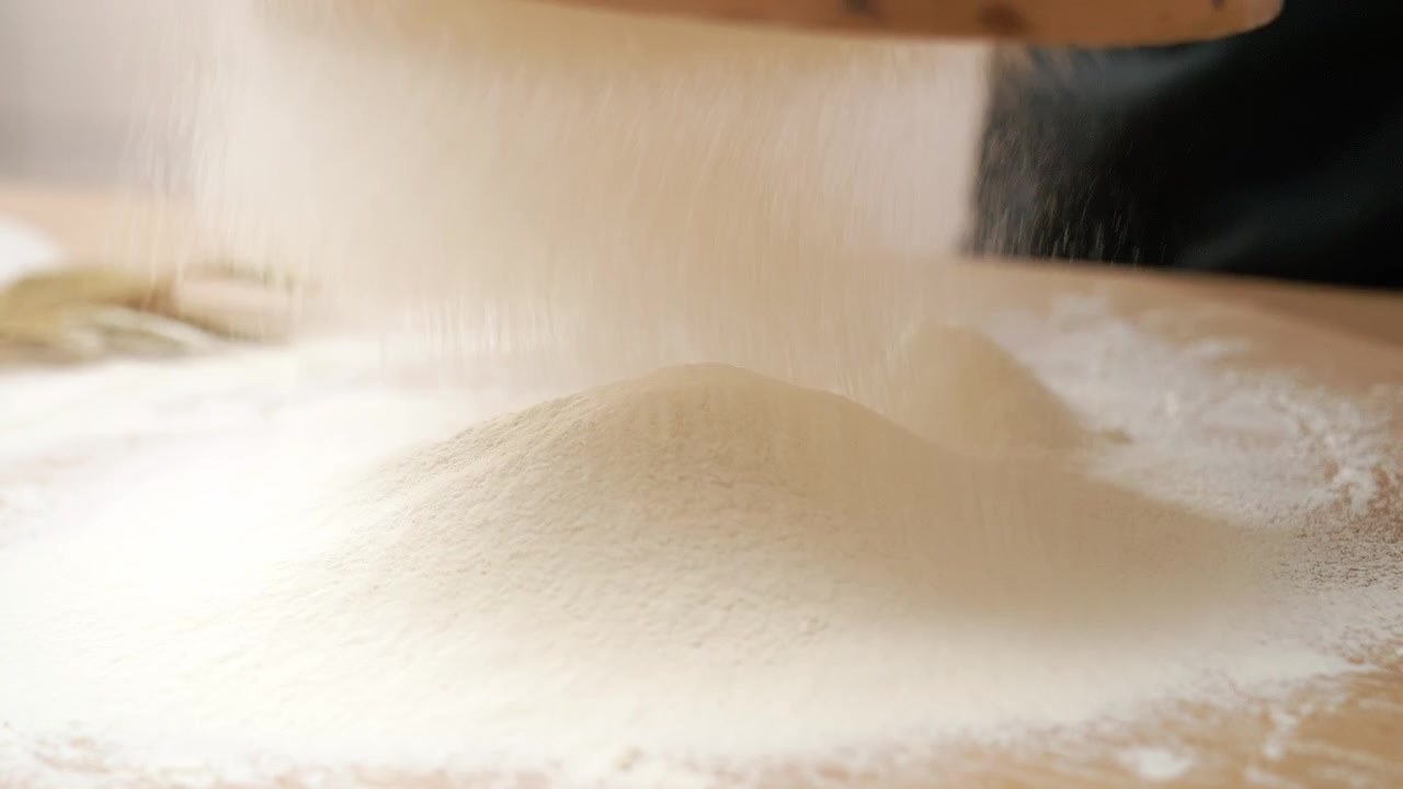 Close-up Tepung Putih Diayak ke Meja Kayu