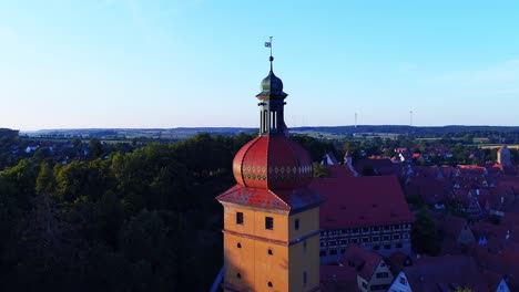 a drone rises slowly past the tower of an ancient city beautiful panorama to the landscape of the old town horizon at sunset aerial view